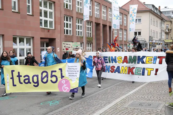Eine bunte Demonstration mit einem Banner auf dem tag05 steht